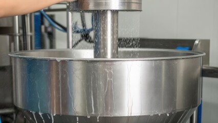 Industrial process with water flowing through a stainless steel machine.
