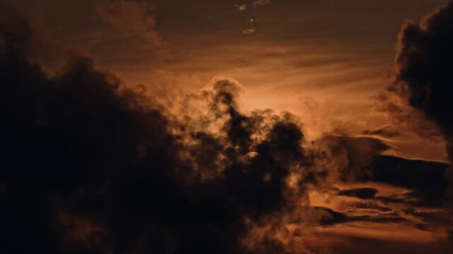 silhouette of a man walking in the mountains aerial shot above beautiful sunset clouds with sun shining through fog, detailed picturesque view, camera moving into amazing cloudscape with beautiful