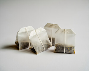 Four delicate tea bags with fine loose leaf tea sit ready for a soothing infusion, promising moments of pure relaxation and comfort.