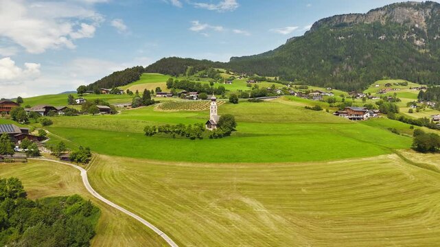 Farm road leading to Chiesa di San Valentino with fields on both sides, aerial view. Rural access to a historic church