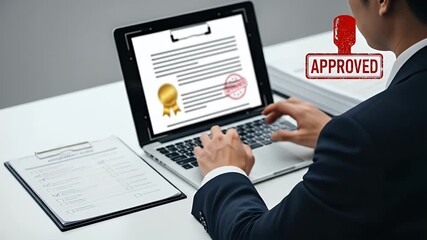 Businessman in Dark Suit Typing on Laptop with Contract Document and Clipboard on White Desk with Approved Stamp Overlay - Powered by Adobe