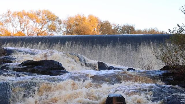 Artificial fish ladder in a river with water flowing over concrete steps, helping wild salmon migrate upstream through the dam, symbol of ecological restoration and sustainable river management, captu