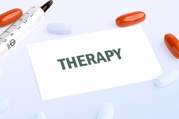A card displays the word Therapy, surrounded by medication. The setup features a syringe, red...