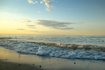 Beach At Sunset With Calm Waves Lapping Up On Shore