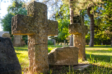 Stone Gravestone Crosses In A Church Graveyard At Sunset