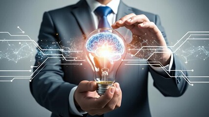 Businessman in Gray Suit Holding Illuminated Brain Bulb on Gray Backdrop, Representing Innovation and Creative Solutions with Digital Graphic Overlay - Powered by Adobe