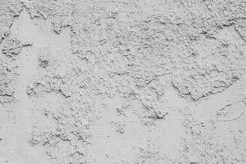 Close-up of an old uneven concrete wall. Close-up of gray worn plaster. 