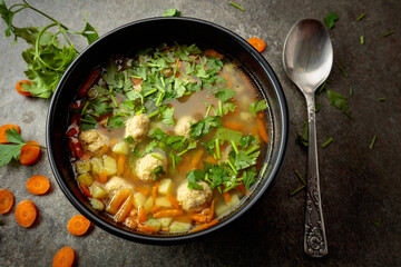 Classic meatball soup with potatoes,  carrot and greens.