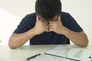 An asian businessman is suffering from headache, tension from forehead and getting stress and depression during working, massaging his head, employee life office stress and office syndrome concept.	
