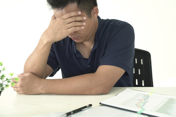 An asian businessman is suffering from headache, tension from forehead and getting stress and depression during working, massaging his head, employee life office stress and office syndrome concept.	
