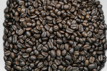Roasted coffee beans, Close-up of freshly mixed site arabica coffee beans in dark roast, with dark brown color, conveys rich taste and aroma. background to advert coffee products, coffee shops.