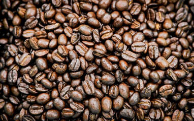 Roasted coffee beans, Close-up of freshly mixed site arabica coffee beans in medium dark roast, with dark brown color, conveys rich taste and aroma. background to advert coffee products, coffee shops.