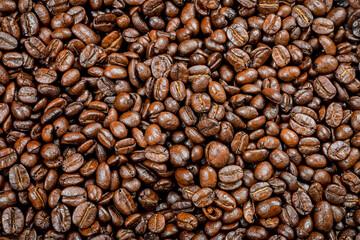 Roasted coffee beans, Close-up of freshly mixed site arabica coffee beans in medium dark roast, with dark brown color, conveys rich taste and aroma. background to advert coffee products, coffee shops.