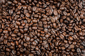 Roasted coffee beans, Close-up of freshly mixed site arabica coffee beans in medium dark roast, with dark brown color, conveys rich taste and aroma. background to advert coffee products, coffee shops.