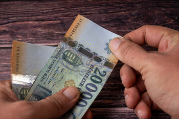Hand holding 20.000 Ft banknotes