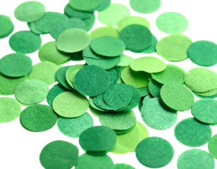 Close-up of a pile of green paper confetti, with varying shades from light to dark on a black background