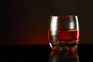 a glass of alcohol and ice cubes