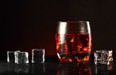 a glass of alcohol and ice cubes