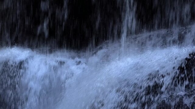 Mystischer Wasserfall eines Wildbaches an einer Bergwand, Alpen
