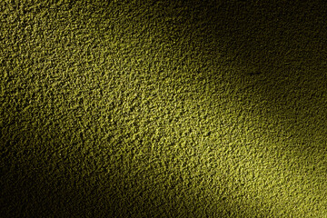 光に照らされた黄金色のざらざらした土壁のテクスチャー