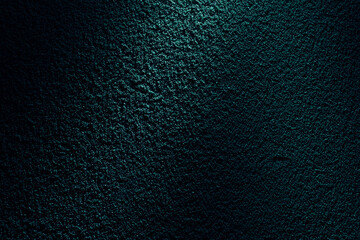 ターコイズグリーンの光に浮かぶざらざらした土壁のテクスチャー
