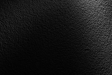 ざらざらした黒い土壁に斜光が当たる重厚なテクスチャー