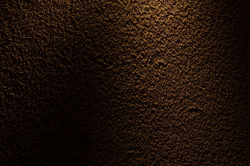 オレンジ色の光が当たるざらざらした土壁のテクスチャー