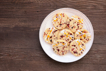 Christmas holiday cranberry orange icebox cookies. Top down view on a dark wood background.