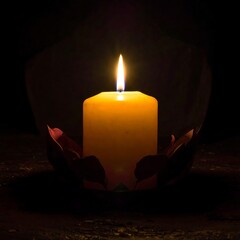 Close-up of a lit candle, set within a decorative base, black background
