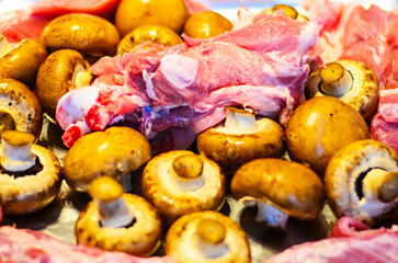Fresh raw meat and mushrooms ready for cooking, close-up shot