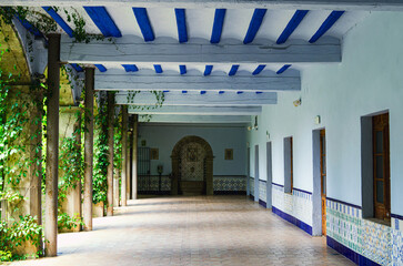 Spanish hacienda courtyard corridor with columns and blue beams