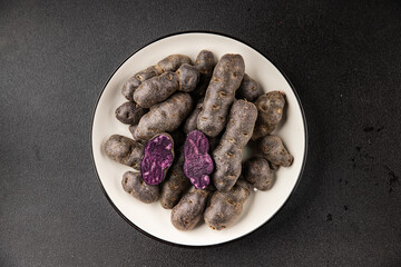 Purple potatoes raw fruit blue potatoe vegetable dish fresh gourmet food background on the table rustic food top view copy space keto and paleo diet vegan and vegetarian food