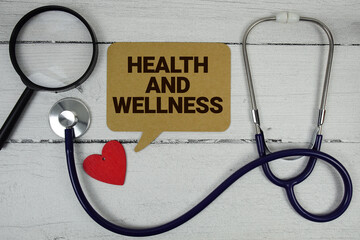 Health And Wellness text with Red heart, Magnifying glass and Medical Stethoscope on wooden background