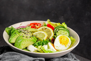 Avocado salad egg, tomato, onion, green leaf salad vegetable dish natural tasty snack fresh gourmet food background on the table rustic top view copy space keto and paleo diet vegan and vegan food