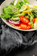 Avocado salad egg, tomato, onion, green leaf salad vegetable dish natural tasty snack fresh gourmet food background on the table rustic top view copy space keto and paleo diet vegan and vegan food