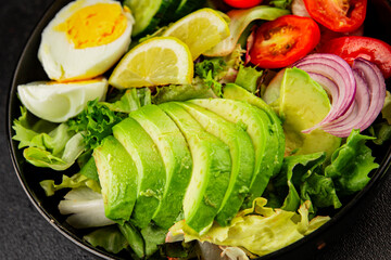 Avocado salad egg, tomato, onion, green leaf salad vegetable dish natural tasty snack fresh gourmet food background on the table rustic top view copy space keto and paleo diet vegan and vegan food