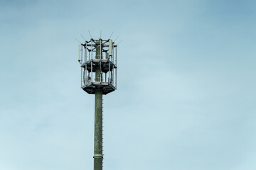 Cell tower standing tall against a cloudy sky in a rural area showcasing telecommunication infrastructure