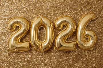 Golden 2026 new year balloons on sparkling glitter background celebrating festive holiday season