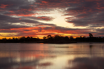 Jesienny, pomarańczowy wschód słońca nad stawem, tapeta. © mycatherina