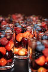 Colorful fresh berries in clear glass cups for elegant events