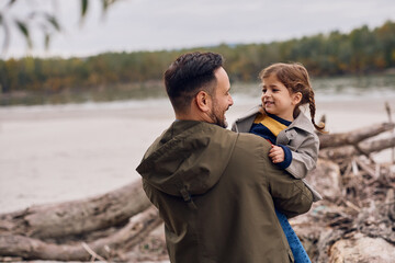 Happy father and daughter enjoying in nature in autumn.