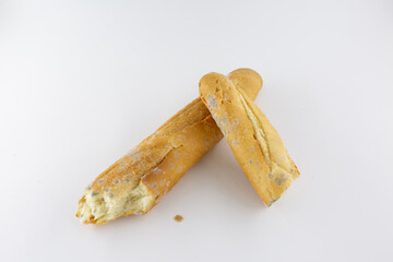 Two baguette pieces with visible mold placed on a clean white background. Represents the theme of decay, waste, and time.