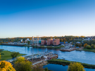 Obraz premium Construction site of new modern bridge construction in Kaunas, Lithuania. Aerial drone view of bridge connecting two shores of a river. Work progress