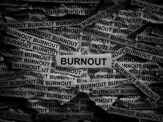 Strips of newspaper with the words Burnout typed on them. Black and white. Close up.