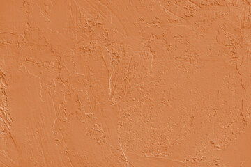 Close up, macro of orange painted textured stucco wall with rough plaster, concrete surface texture. Abstract background, backdrop for design, wallpaper art or decoration projects.
