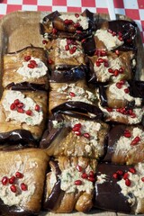 Grilled eggplant rolls with creamy filling and pomegranate seeds, perfect for food blogs or Mediterranean cuisine features.