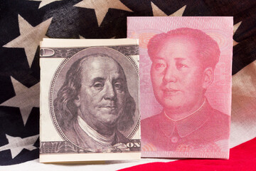 US and Chinese money against the background of the US flag. The concept of a trade war between the...