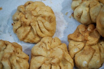 Close-up of golden fried dumplings with intricate folds, perfect for food photography or Asian cuisine showcases