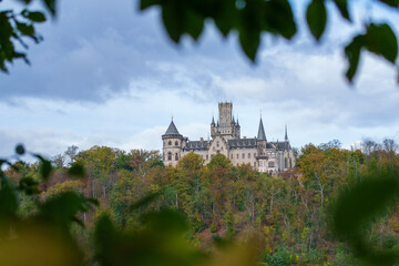Marienburg Castle - Gothic revival castle in Lower Saxony, Germany. A Scenic Castle That Gracefully Overlooks a Lush Green Valley Surrounded by Nature in autumn.