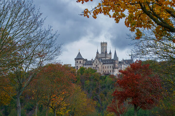 Marienburg Castle - Gothic revival castle in Lower Saxony, Germany. A Scenic Castle That Gracefully Overlooks a Lush Green Valley Surrounded by Nature in autumn.